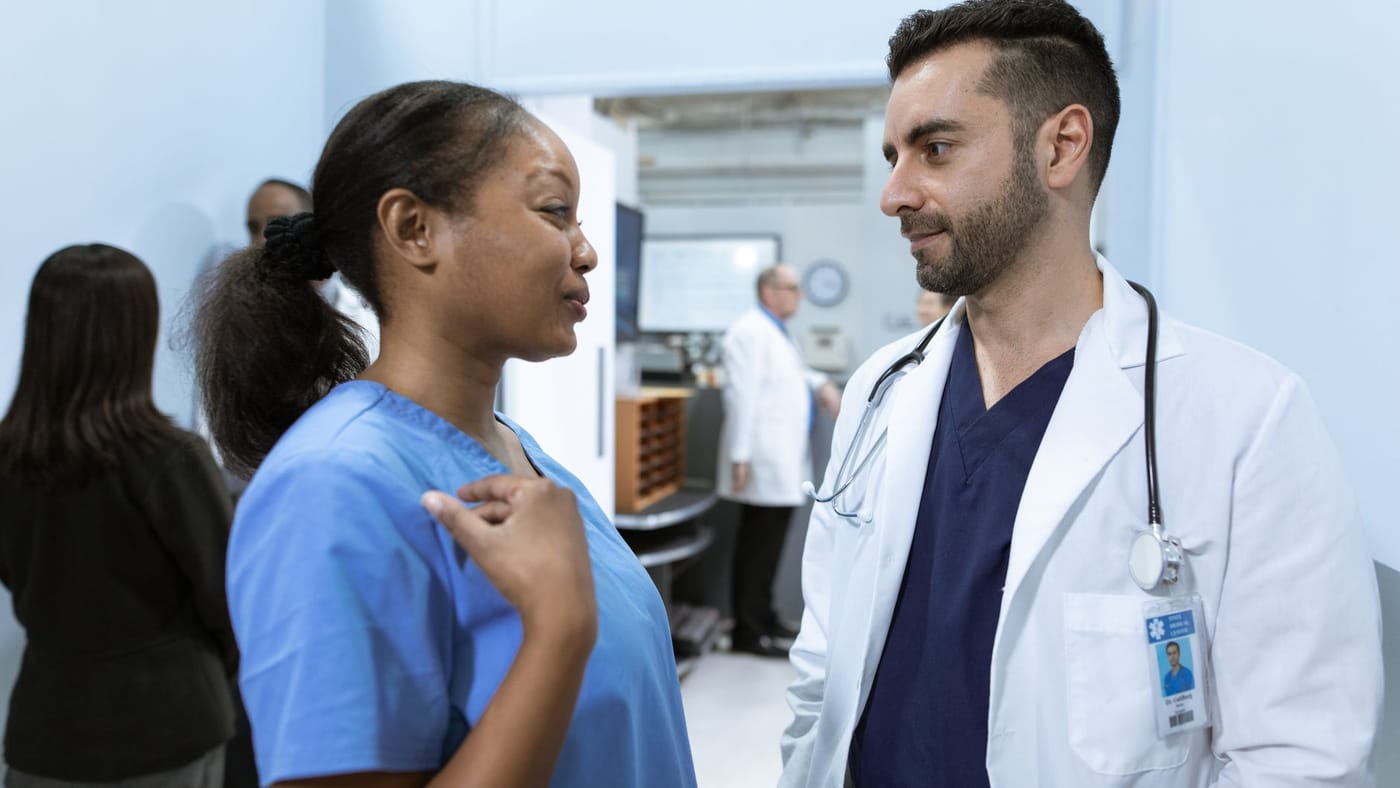 Profissional de saúde conversando com um paciente durante a consulta