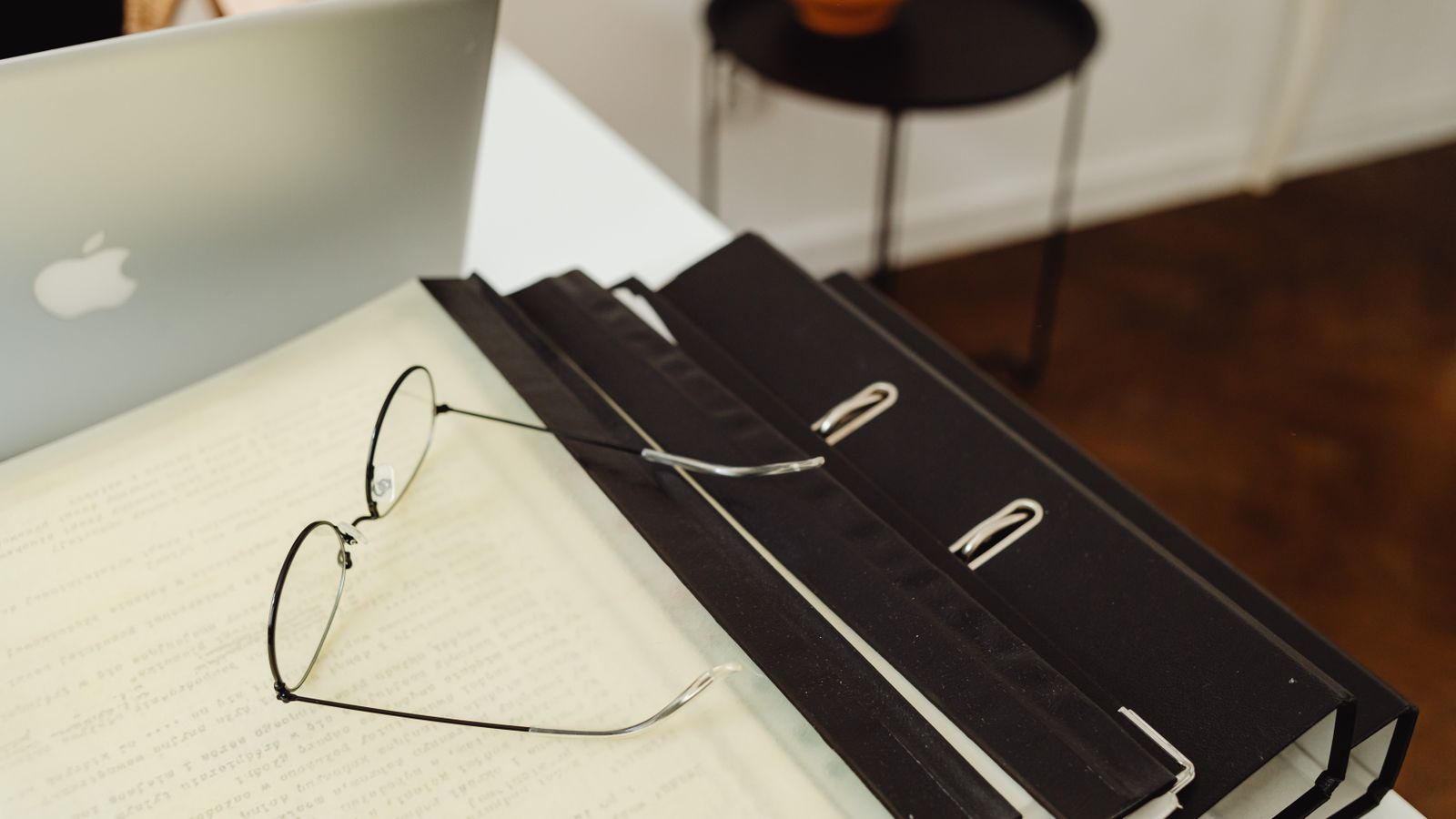 Notebook sobre mesa clara de consultório moderno, com pastas de prontuários ao lado e sem pessoas